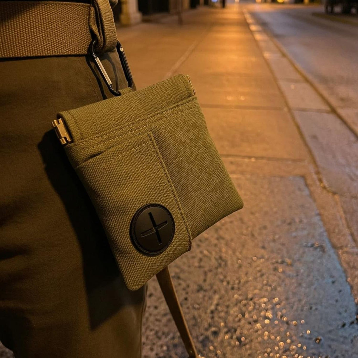 Olivgrön canvasväska buren i byxlinningen på en kvällspromenad